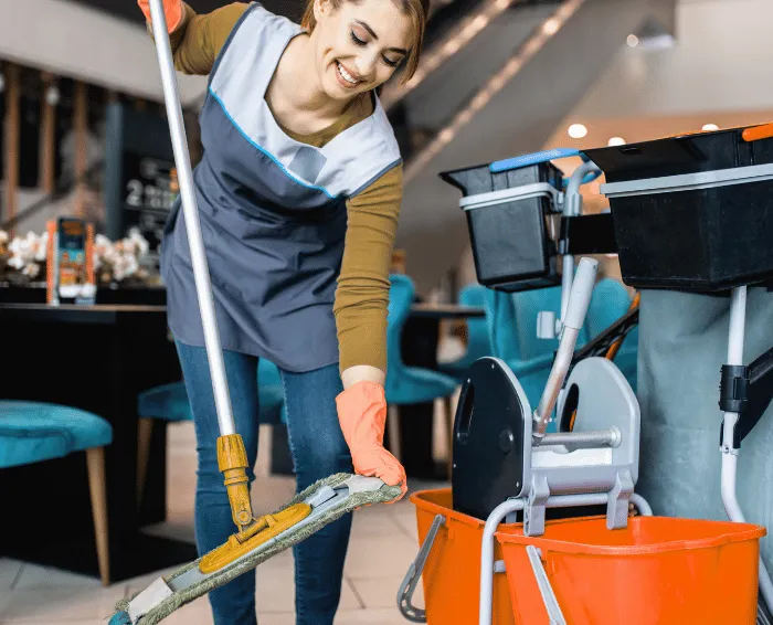 Sprzątanie obiektów w Lublinie – pracownica sprzątająca myje podłogę i przygotowuje sprzęt serwisowy