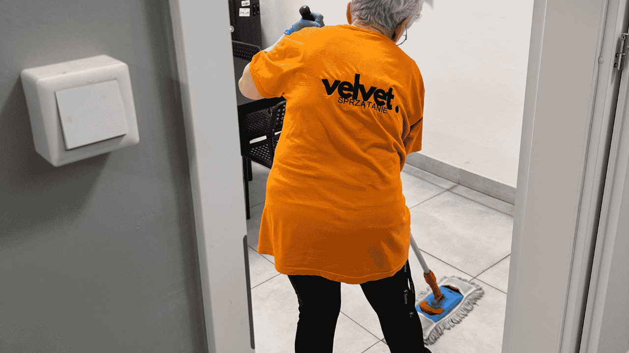 Pracownik Velvet Sprzątanie myjący podłogę w pomieszczeniu technicznym budynku