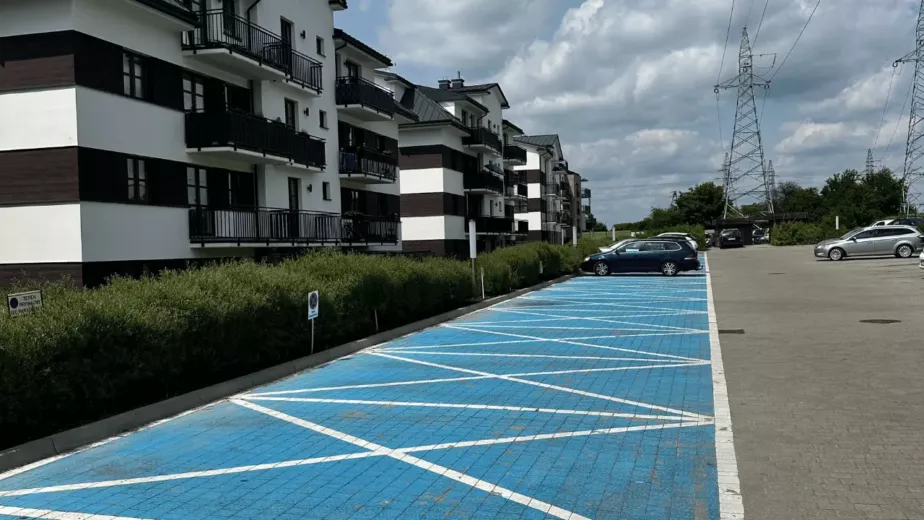 Czysty parking przy budynku mieszkalnym i przykład profesjonalnego utrzymania terenów zewnętrznych