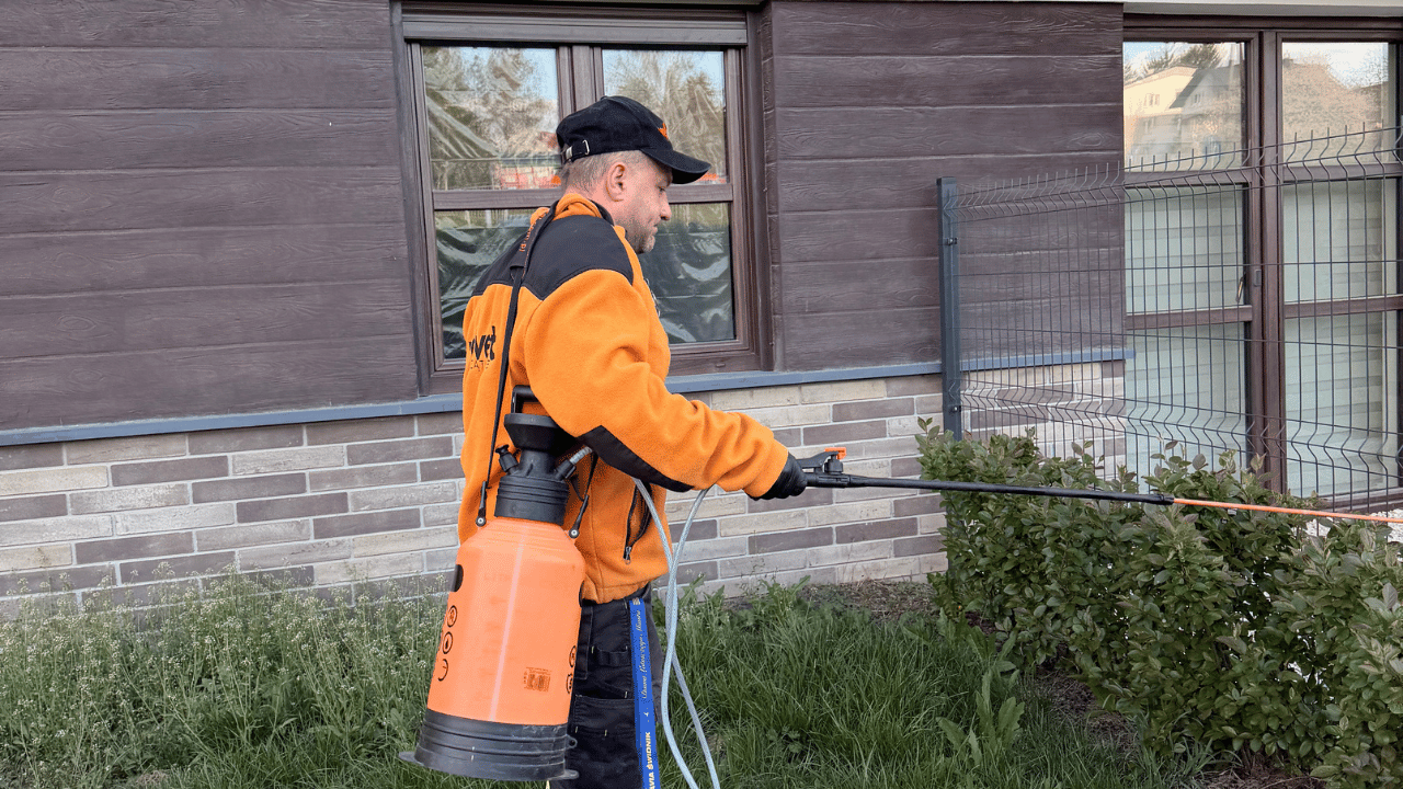 Pracownik Velvet Sprzątanie podczas pielęgnacji krzewów i terenów zewnętrznych osiedla mieszkaniowego