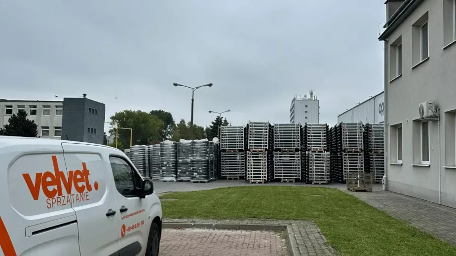 Samochód Velvet Sprzątanie przy terenie zielonym obok magazynu i placu firmowego