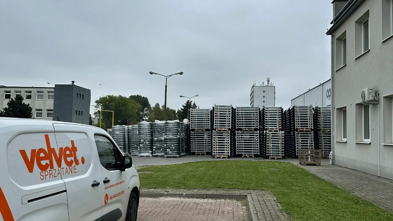 Samochód Velvet Sprzątanie przy terenie zielonym obok magazynu i placu firmowego